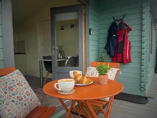 ニューカッスルにあるMountainside Cabinのポーチに置かれたコーヒーとパンの入ったテーブル