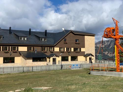 a large building with a playground in front of it at Hotel Port 1730 in La Coma i la Pedra
