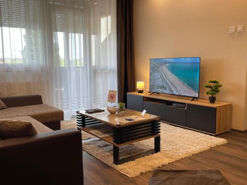 a living room with a tv and a coffee table at City Edge Hideaway Apartment in Nagykanizsa