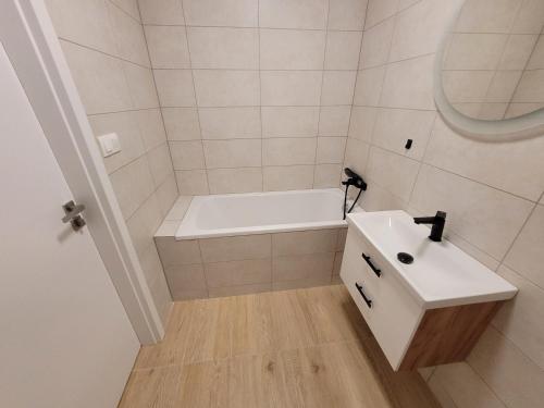 a bathroom with a white tub and a sink at Apartmán Neva Šaľa in Šaľa
