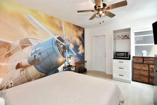 1 dormitorio con un mural de avión en la pared en Blue Mist Motel - Room # 3, en Daytona Beach