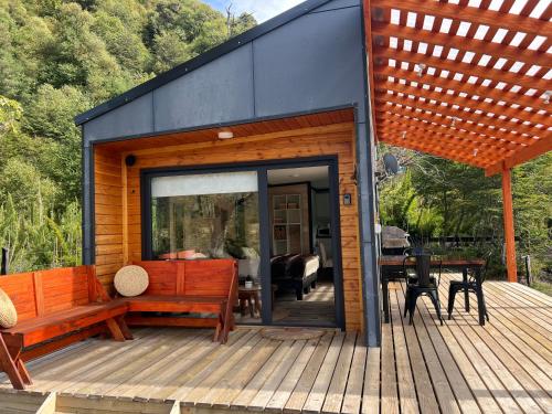 a tiny house with a bench on a deck at Tiny House 2 a 3 per Malalcahuello Wifi Satelital in Malalcahuello