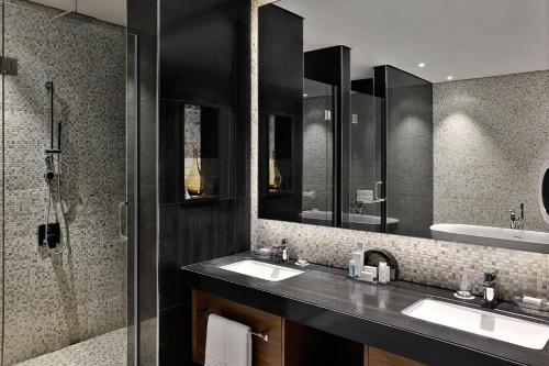 a bathroom with two sinks and a shower at Marriott Riyadh Diplomatic Quarter in Riyadh