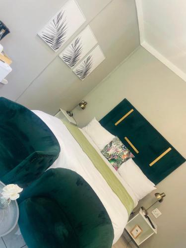 a bedroom with a bed with green sheets and pillows at The Bliss Boutique in Louis Trichardt