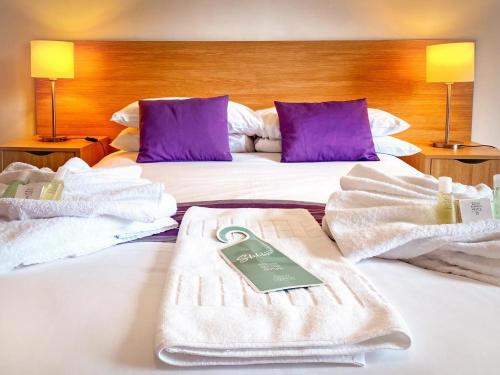 a hotel room with a bed with towels on it at Tor Park Hotel in Torquay