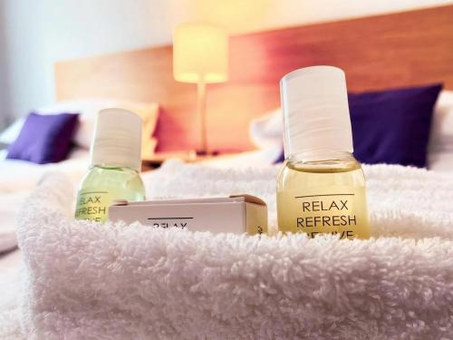 two bottles of essential oils sitting on a white bed at The Tor Park Hotel in Torquay