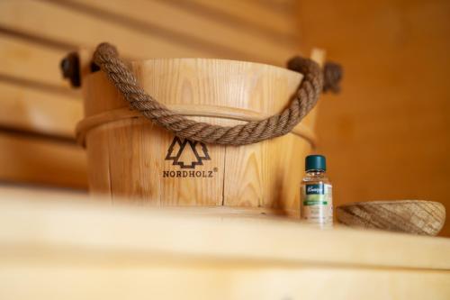 een fles essentiële olie naast een houten zak bij SAUERLAND CHALETS - "Die Chalets am Bergelchen" in Winterberg