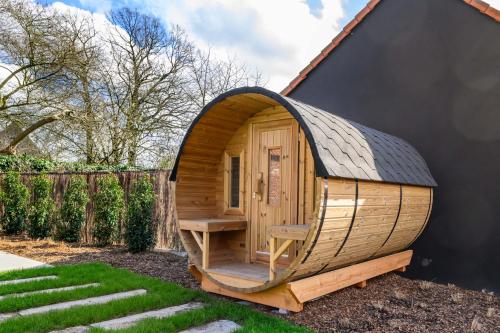 a wooden hobbit house with a peaked roof at Huis Velzeke in Zottegem