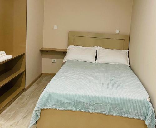 Schlafzimmer mit einem Bett mit einer blauen und weißen Bettdecke in der Unterkunft Tbilis in Tbilisi City