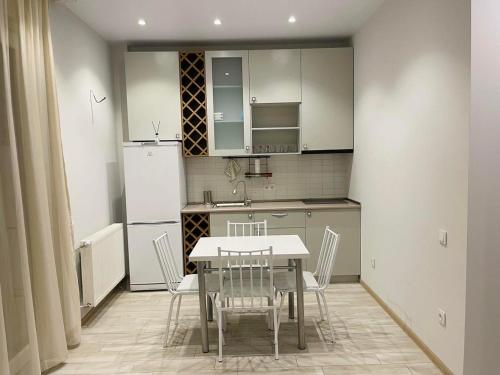 eine Küche mit einem Tisch und Stühlen sowie einem Kühlschrank in der Unterkunft Tbilis in Tbilisi City