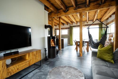 a living room with a flat screen tv and a couch at SAUERLAND CHALETS - "Die Chalets am Bergelchen" in Winterberg