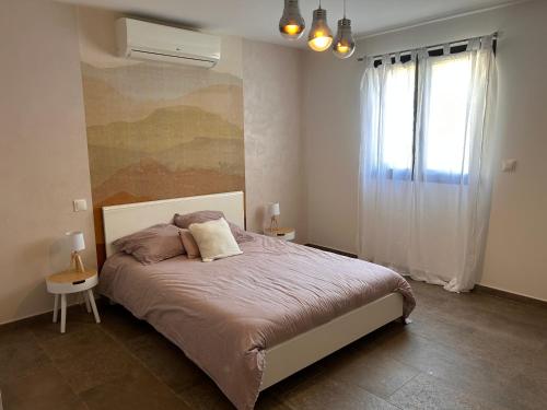 une chambre avec un grand lit et une fenêtre dans l'établissement Villa 3 chambres avec piscine privative, à Ajaccio
