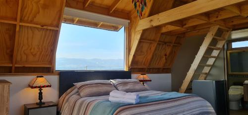 ein Schlafzimmer mit einem Bett in einem Zimmer mit einer Leiter in der Unterkunft Refugio entre el cielo in Guatavita