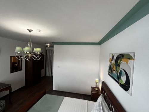 a bedroom with a bed and a painting on the wall at Riviera 990 - Resort & Restaurant in Eşelniţa