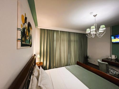 a hotel room with a bed and a chandelier at Riviera 990 - Resort & Restaurant in Eşelniţa