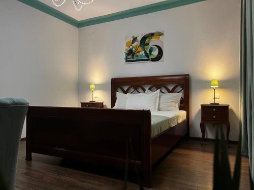 a bedroom with a bed and two night stands with lamps at Riviera 990 - Resort & Restaurant in Eşelniţa