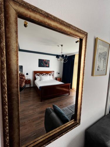 a person taking a picture of a bedroom in a mirror at Riviera 990 - Resort & Restaurant in Eşelniţa
