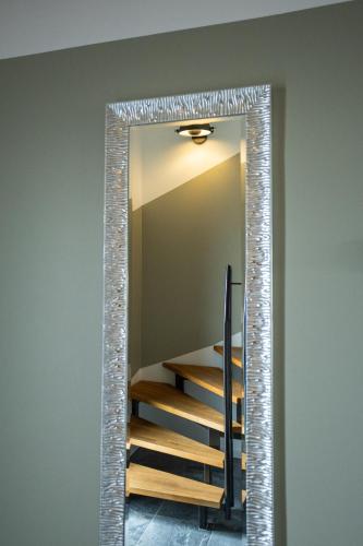 a mirror in a room with a stair case at SAUERLAND CHALETS - "Die Chalets am Bergelchen" in Winterberg
