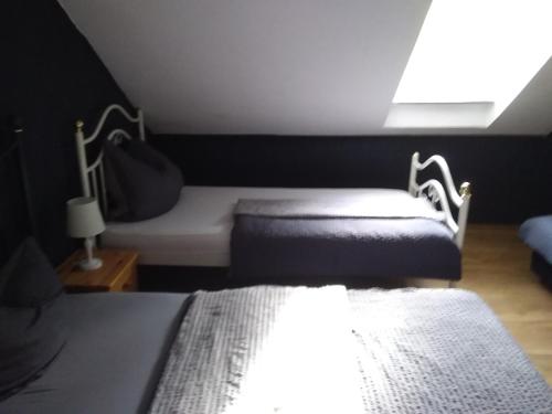 a small bedroom with two beds and a window at Pension Breidbach in Ensch