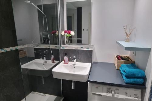 une salle de bain avec deux lavabos et un miroir dans l'établissement Bulle de fraîcheur - Studio confort sur la plage, à La Baule