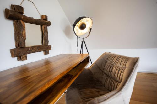 a desk with a fan and a chair in a room at SAUERLAND CHALETS - "Die Chalets am Bergelchen" in Winterberg