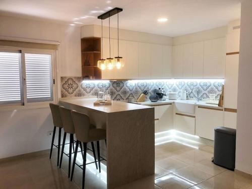 a kitchen with a island with bar stools at Apartamento con impresionantes vistas en Los Gigantes - Crab Island in Puerto de Santiago