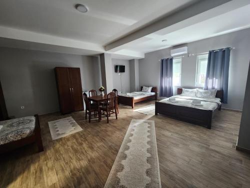 een woonkamer met een bed en een tafel en stoelen bij Hotel Mountain View Inn in Gusinje