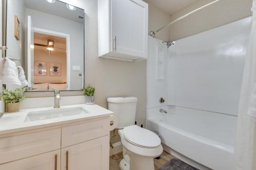 a bathroom with a toilet and a sink and a mirror at Convenient Grand Prairie Apartment with Balcony in Grand Prairie