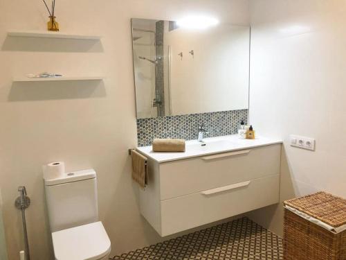 a bathroom with a toilet and a sink and a mirror at Apartamento con impresionantes vistas en Los Gigantes - Crab Island in Puerto de Santiago