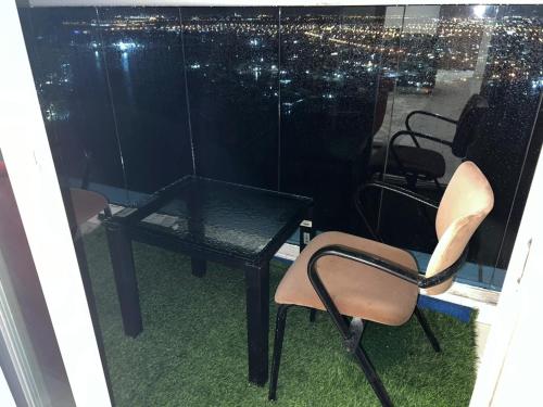 einen Tisch und Stühle in einem Zimmer mit Fenster in der Unterkunft 2bhk oasis tower in Ajman 