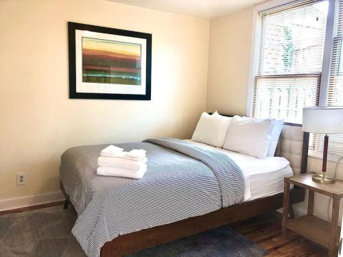 a bedroom with a bed with towels on it at The House Hotels - W20TH - Three Bedroom, Near West Side Market and Downtown Cle in Cleveland