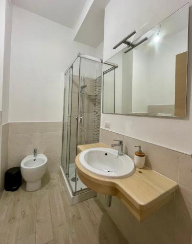 a bathroom with a sink and a shower and a toilet at Dimora La Coccinella - Accommodation in Muravera