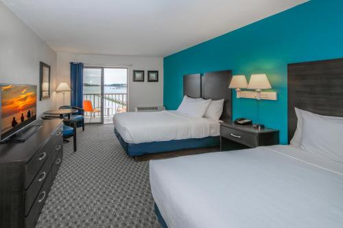 a hotel room with two beds and a television at The Bay Resort in Dewey Beach