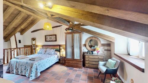 a bedroom with a bed and a chair at Casa Rural La Fuente del Fresno in Caballar