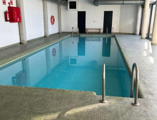 - une piscine d'eau bleue dans un bâtiment dans l'établissement Luminoso y confortable Loft, à Alcobendas