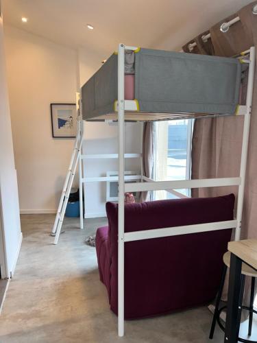a bedroom with a bunk bed and a couch at studio bocagère in Amblainville