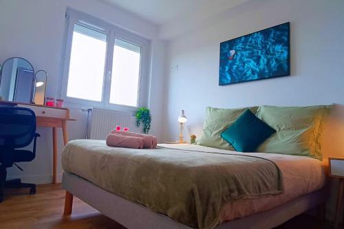 1 dormitorio con 1 cama, escritorio y ventanas en Appartement neuf - 3 chambres - 6 personnes - 73m² vue sur la ville, en Caen
