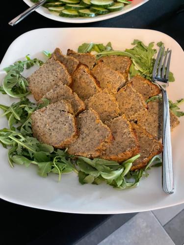 a plate of food with a sandwich and greens at Villa Park in Siedlce