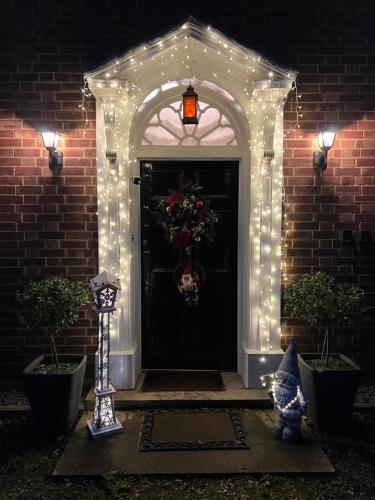 a front door with lights and a wreath on it at Beightons Bed and Breakfast in Bury Saint Edmunds