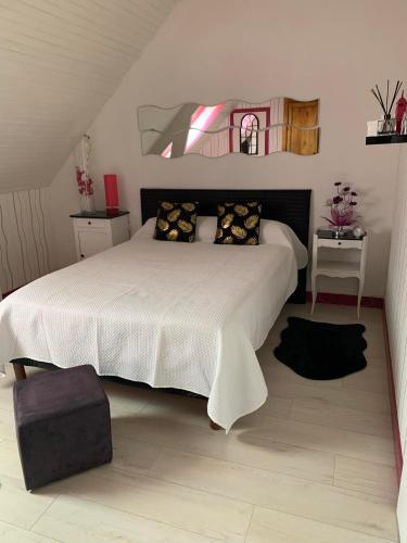 une chambre avec un grand lit blanc avec des oreillers dans l'établissement Les Grillettes, à Ploërmel