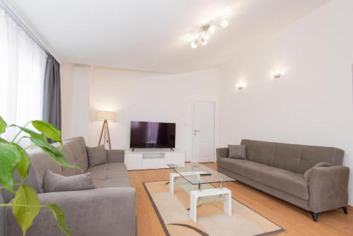 uma sala de estar com dois sofás e uma televisão em Hillside Vista Apartments em Tivat