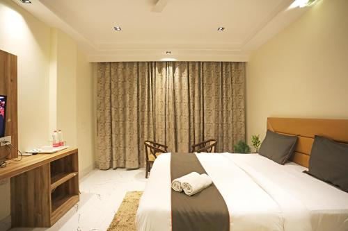 Habitación de hotel con cama grande y escritorio. en Hotel GOOD LUCK HOUSE Near Delhi Airport, en Nueva Delhi
