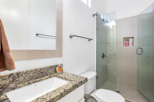 uma casa de banho com um WC e uma cabina de duche em vidro. em Jr Suite 4 - Playa Arcangel em Rosarito