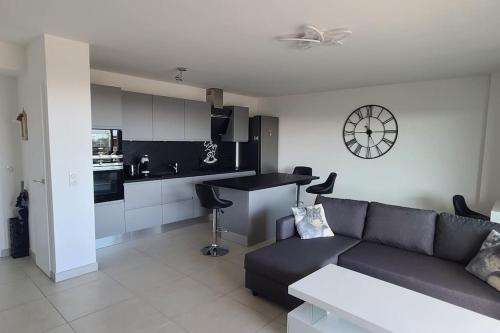 un salon avec un canapé et une cuisine dans l'établissement Beau T3 - Meublé classé 3*- Vue dégagée sur Marina, à Canet