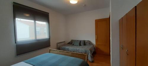 a small bedroom with a bed and a window at Casa Airen con jacuzzi in Miguel Esteban