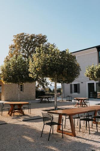 a group of tables and benches in front of a building at Garenne in Livron-sur-Drôme