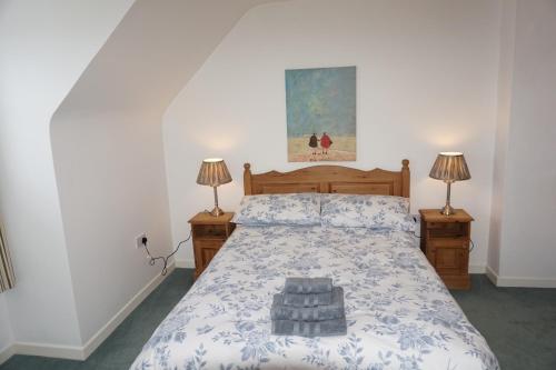 a bedroom with a large bed with two lamps on both sides at 18 Ballybunion Holiday Cottages in Ballybunion