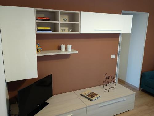Habitación con escritorio, TV y estante. en Profumo Barocco 1, en Noto