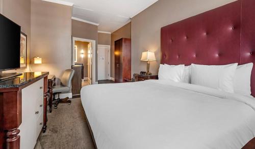 ナッシュビルにあるBluegreen Downtown Nashvilleの赤いヘッドボード付きの大きなベッドが備わるホテルルームです。