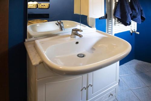 bagno con lavandino bianco e vasca di La Mansardina Beccheria Central Apartment 1 double bedroom, 1 sofa bed a Lucca